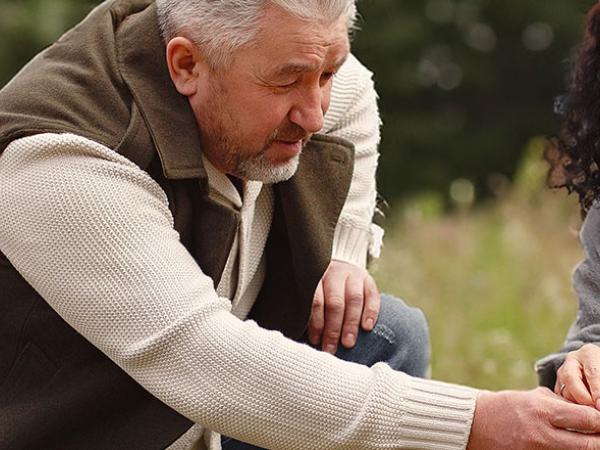 Un homme et une femme ramassent des fleurs dans un pré