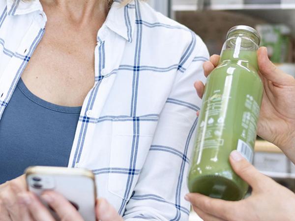 Deux personnes au supermarché regarde l'étiquette d'une bouteille