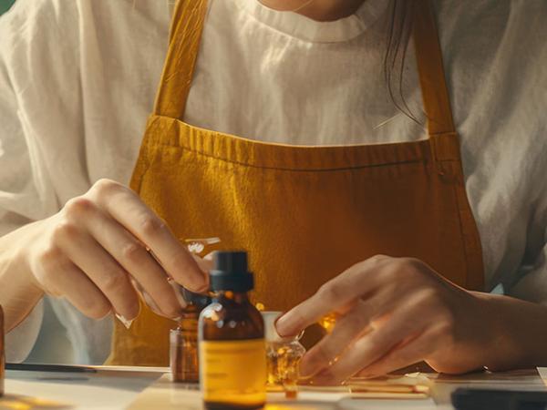 Une femme fait une composition avec des huiles essentielles