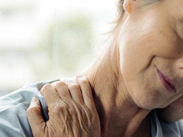 Une femme se tient le cou pour soulager sa douleur