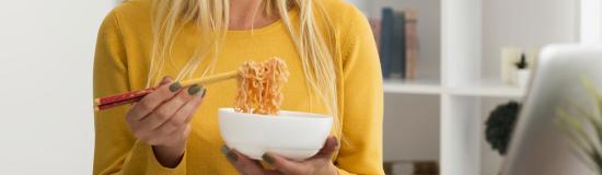 Une femme mange devant son ordinateur